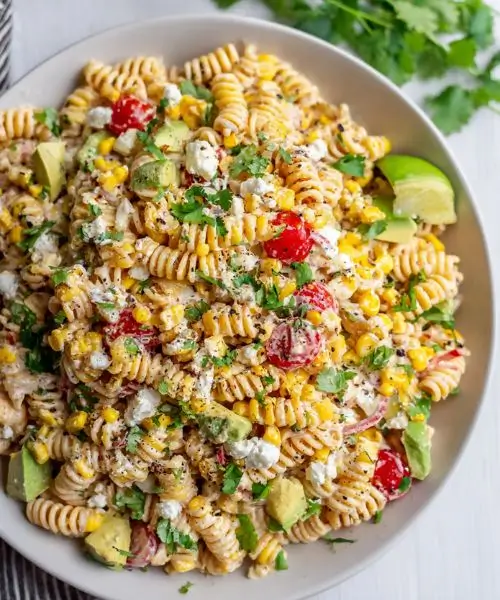 healthy street corn pasta salad with corn avocado and feta