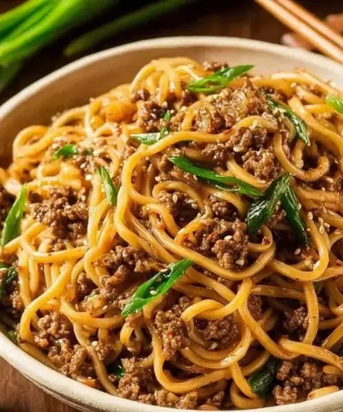 Bowl of Mongolian ground beef noodles with green onions and sesame seeds